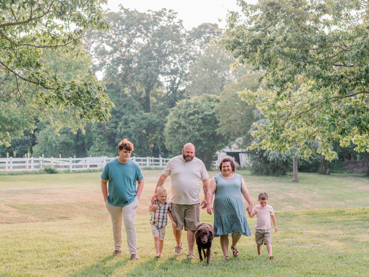 Family and their dog walking in state park.