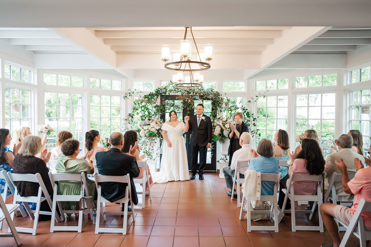 wedding ceremony in the cafe at Frick Museum with guests cheering on the married couple
