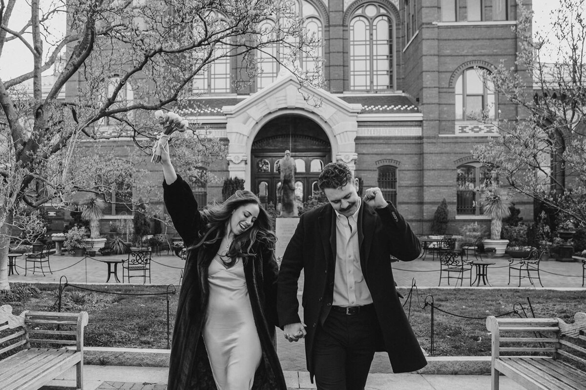 Newlyweds celebrating as they walk hand in hand 