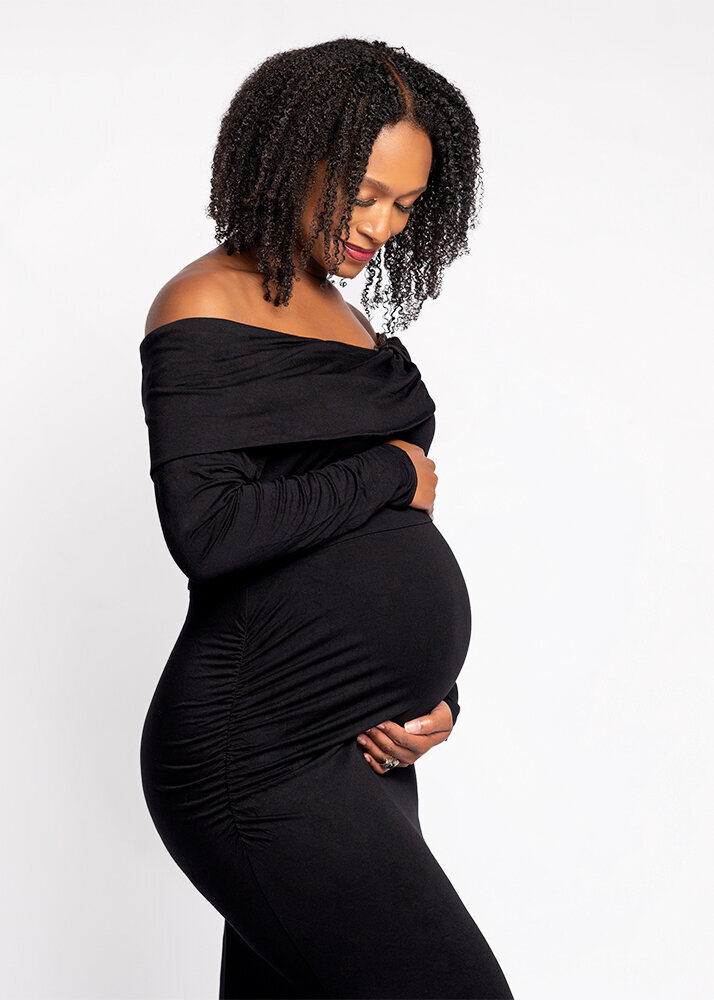 pregnant-african-american-woman-in-black-dress-looking-down