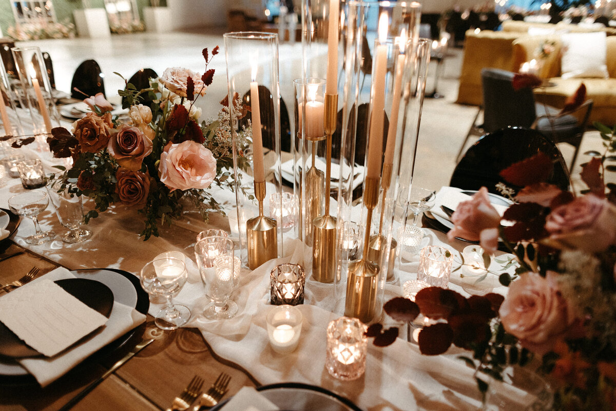 Gorgeous centerpieces bring warmth to this art deco 1920s inspired wedding with hues of terra cotta, dusty pink, mauve, and burgundy. Lush roses, ranunculus, and copper beech highlight the florals. Designed by Rosemary and Finch in Nashville, TN.