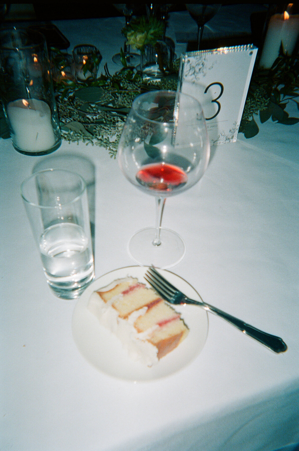 cake and wine abandoned at a reception table at a wedding