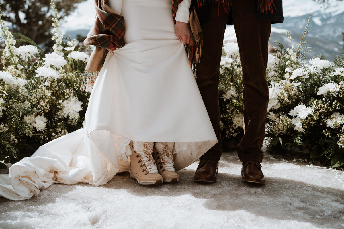Close-up of bride’s snow boots under dress during winter wedding in Breckenridge, Colorado.