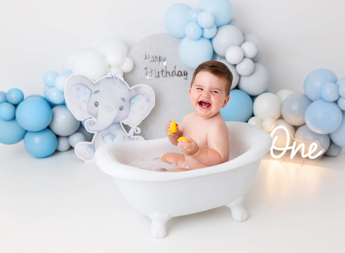 Baby in the bubble bath laughing during his 1st birthday photoshoot 