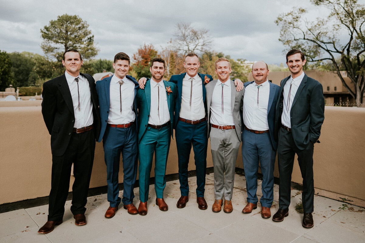 Groom poses with his groomsmen on his wedding day.