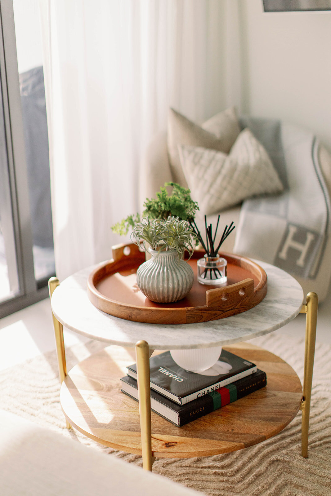 Wooden accent plate on marble side table with gold legs