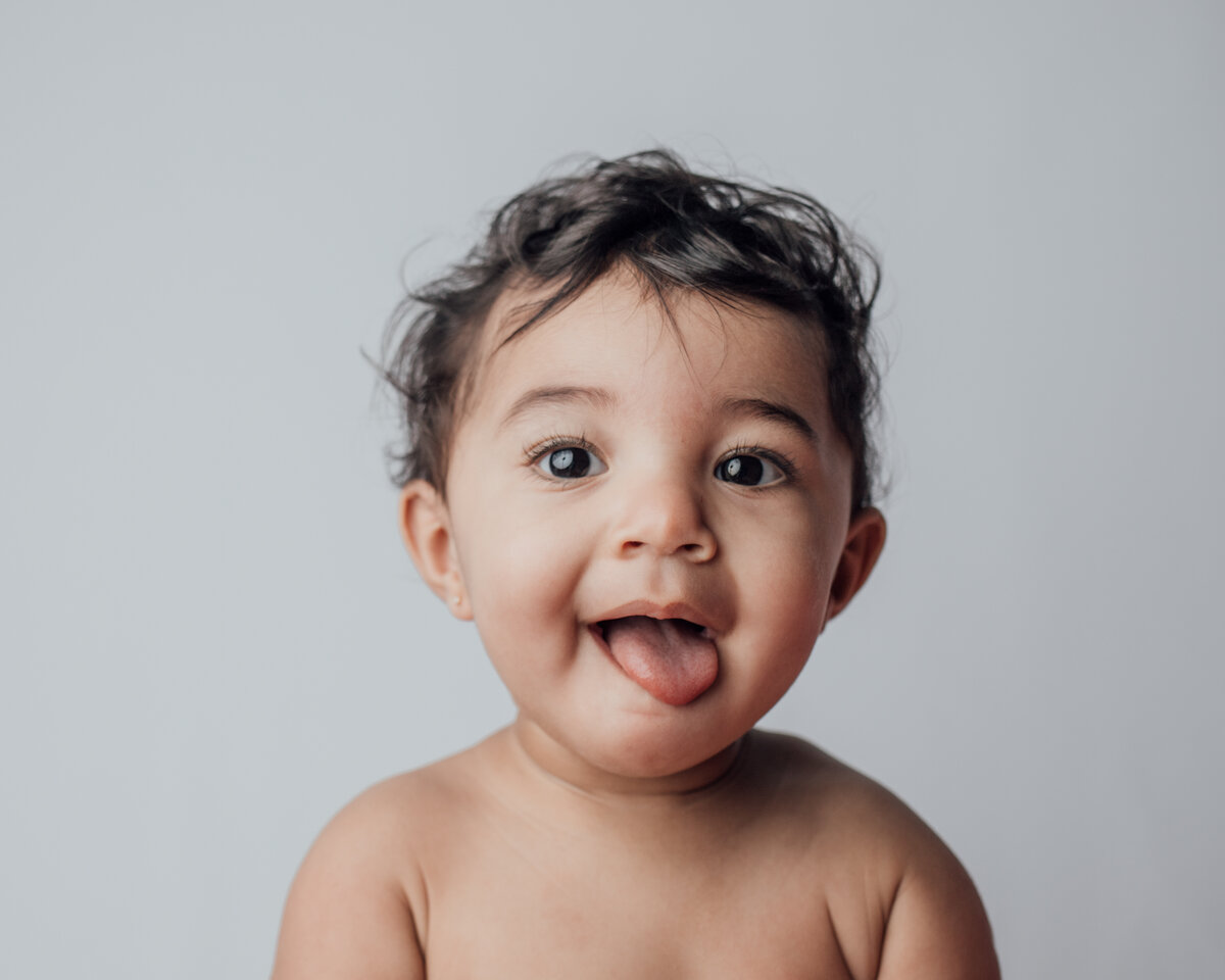 One-year-old baby grinning during milestone photo session in Austin