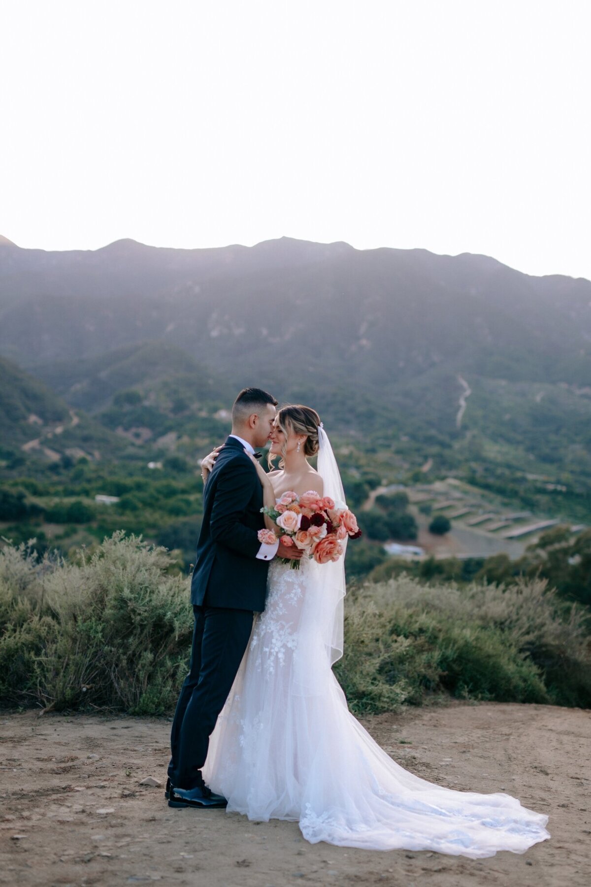 Bride and Groom gazing at one another right before sundown  in front of the mountains in Temecula CA.