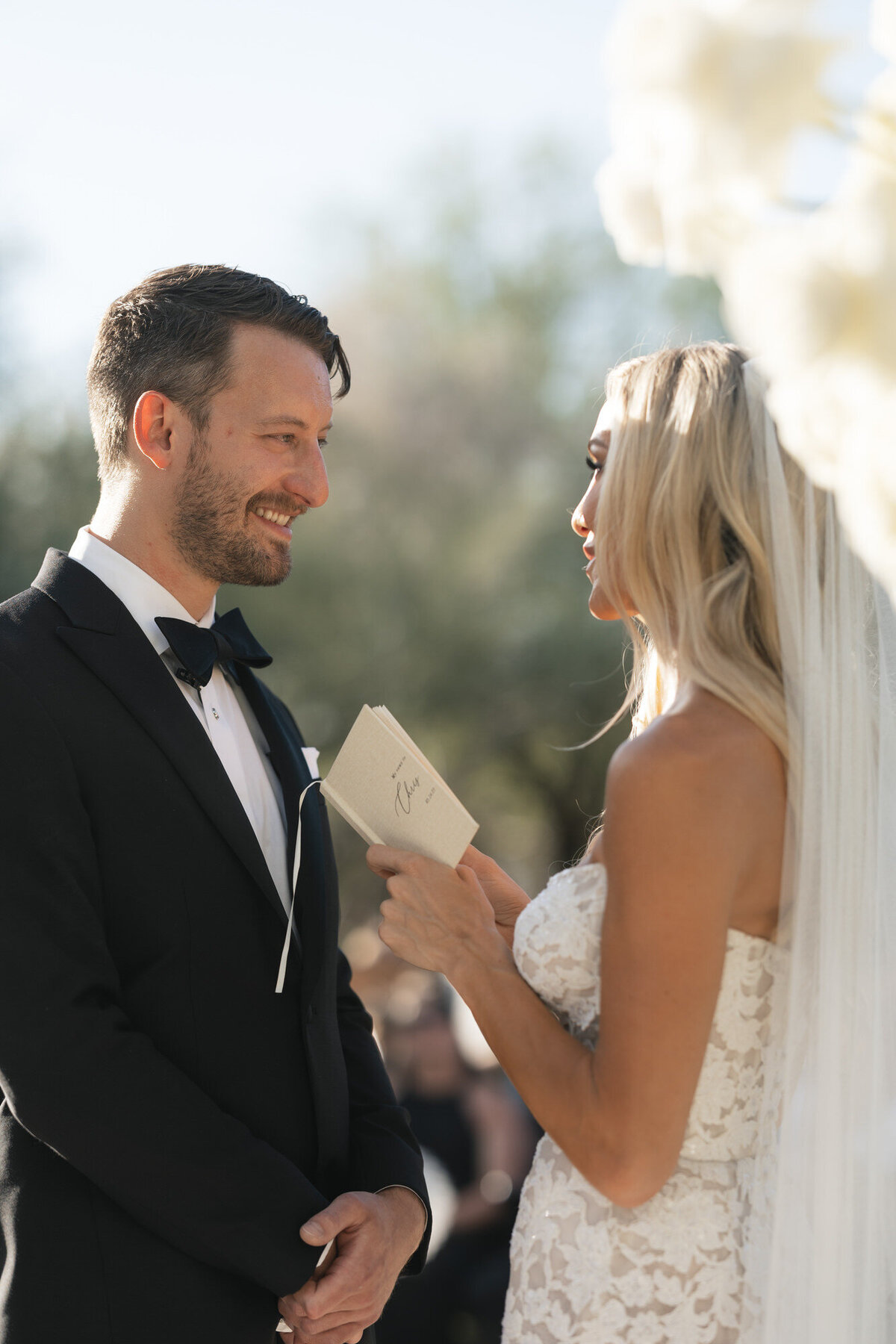Bride sharing vows with groom during wedding ceremony at El Chorro in Paradise Valley, Arizona