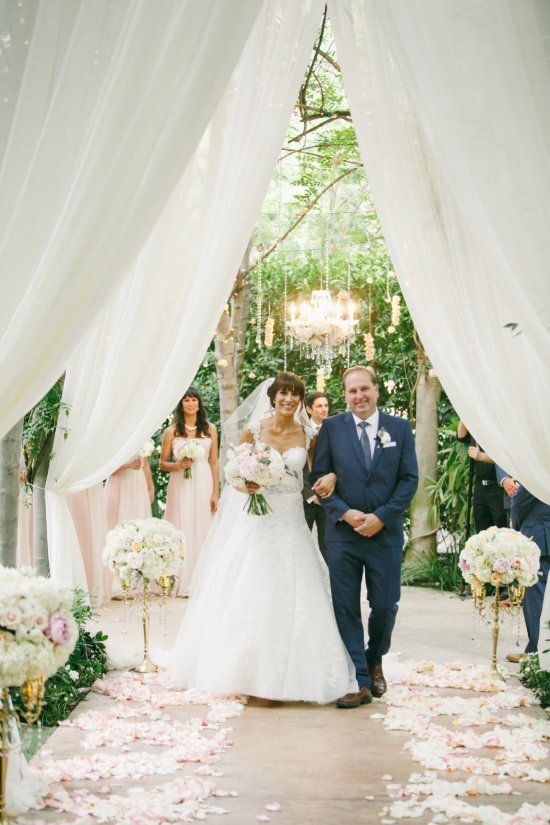 bride and groom walking through a curtain
