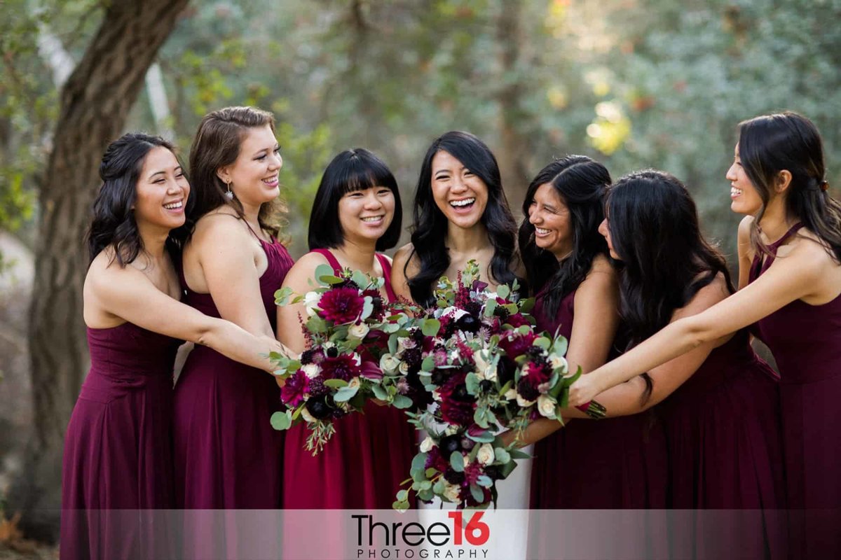 Bride and her Bridesmaids pose with their bouquets all in