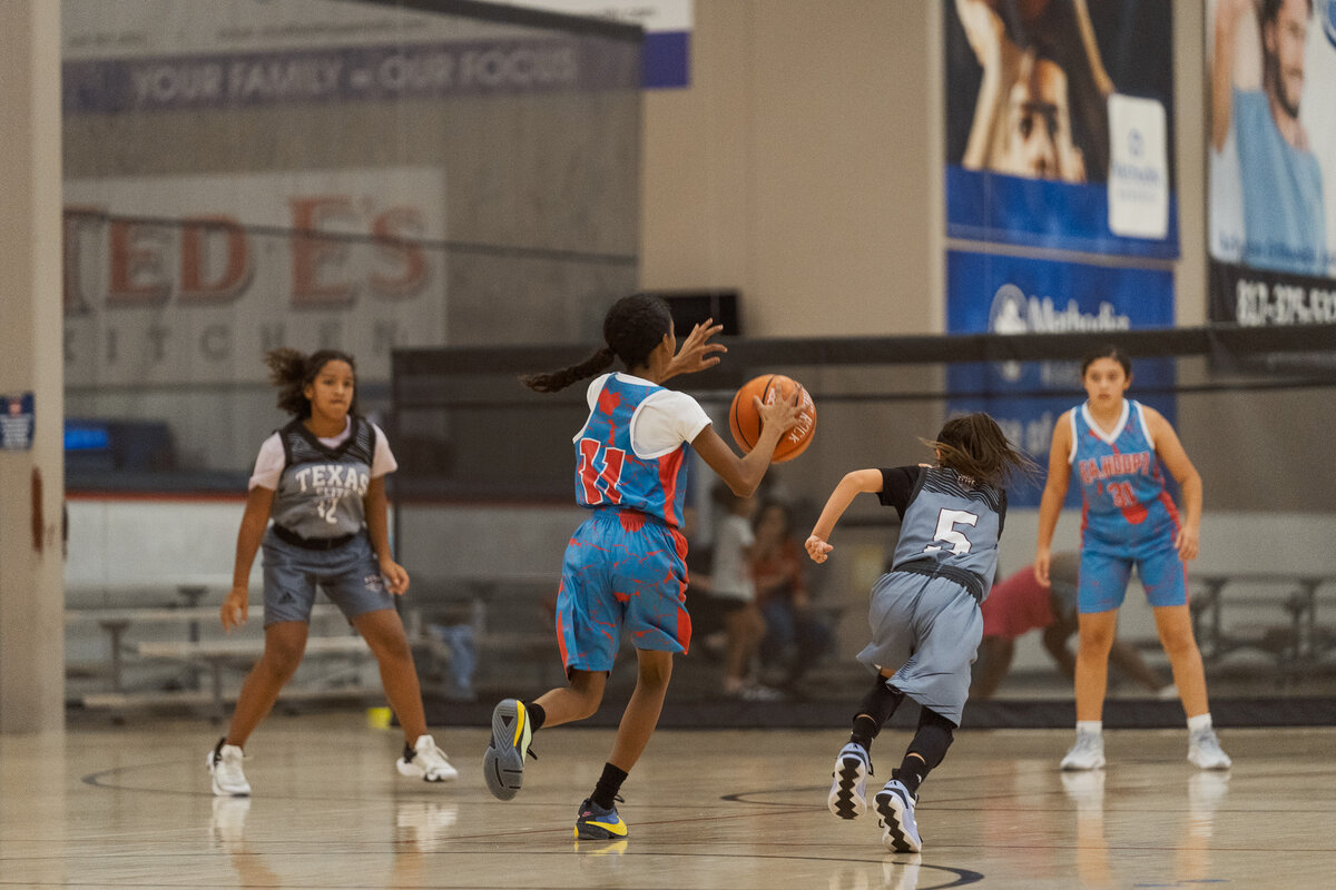 Full Circle Basketball TX player dribbling past defender during a youth basketball match in Fort Worth.