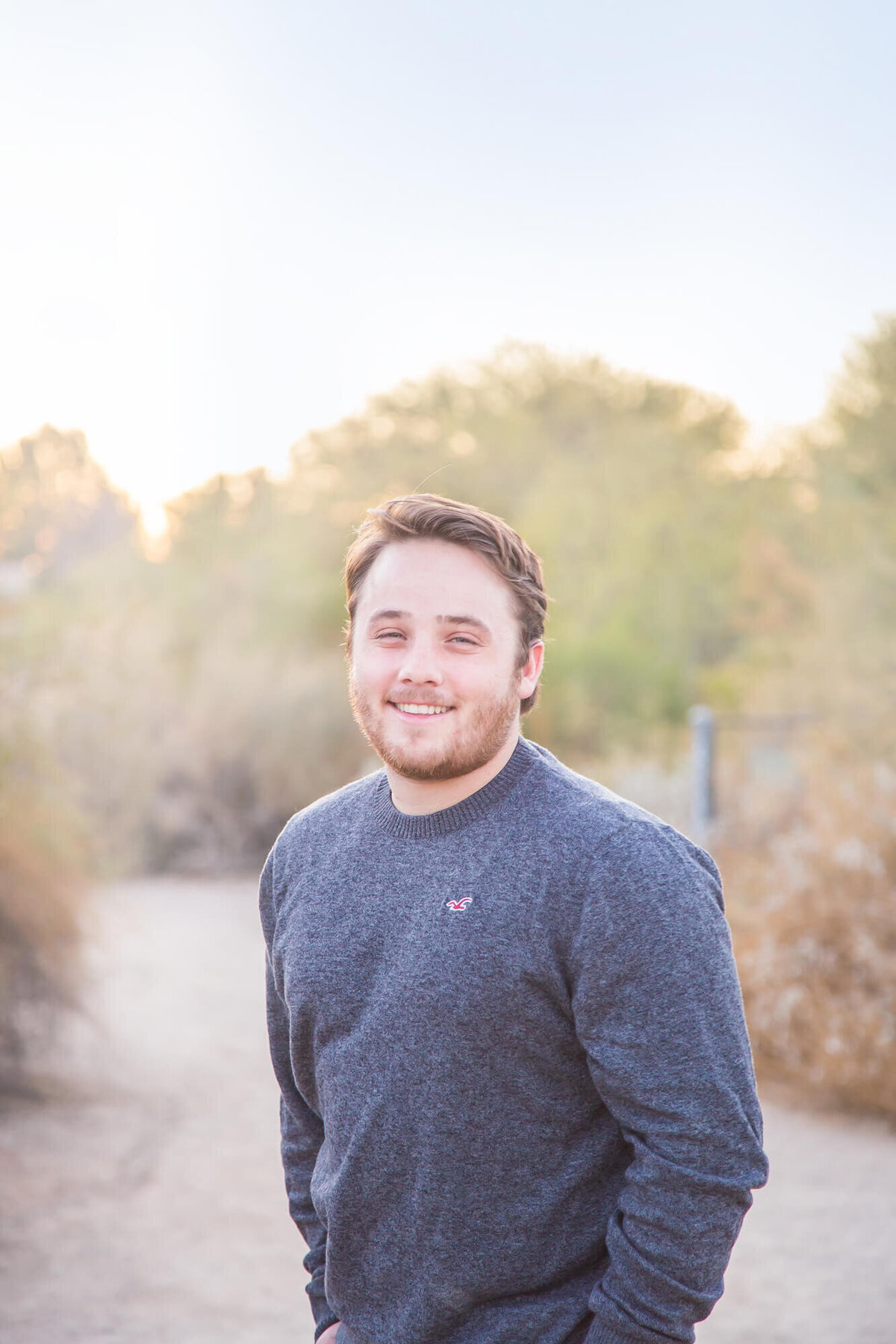 brown haired man in blue gray long sleeved shirt on desert path