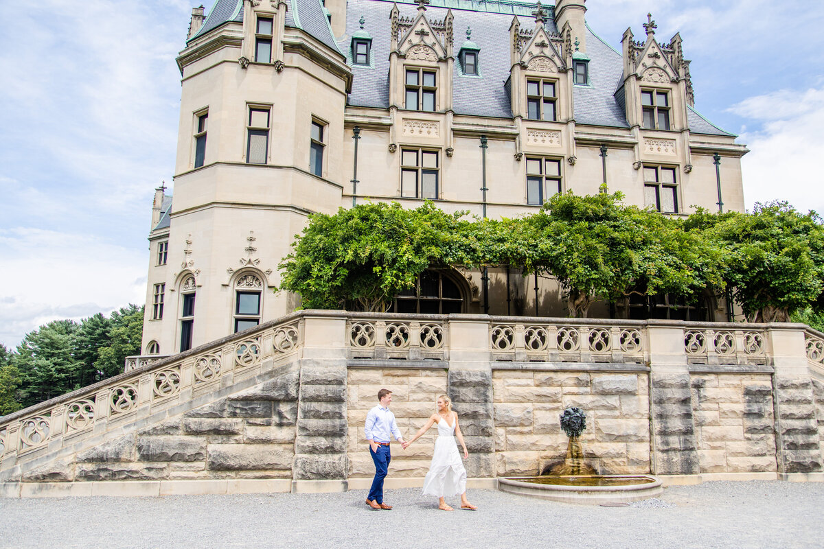 couple facing each other with Biltmore Estate in the background