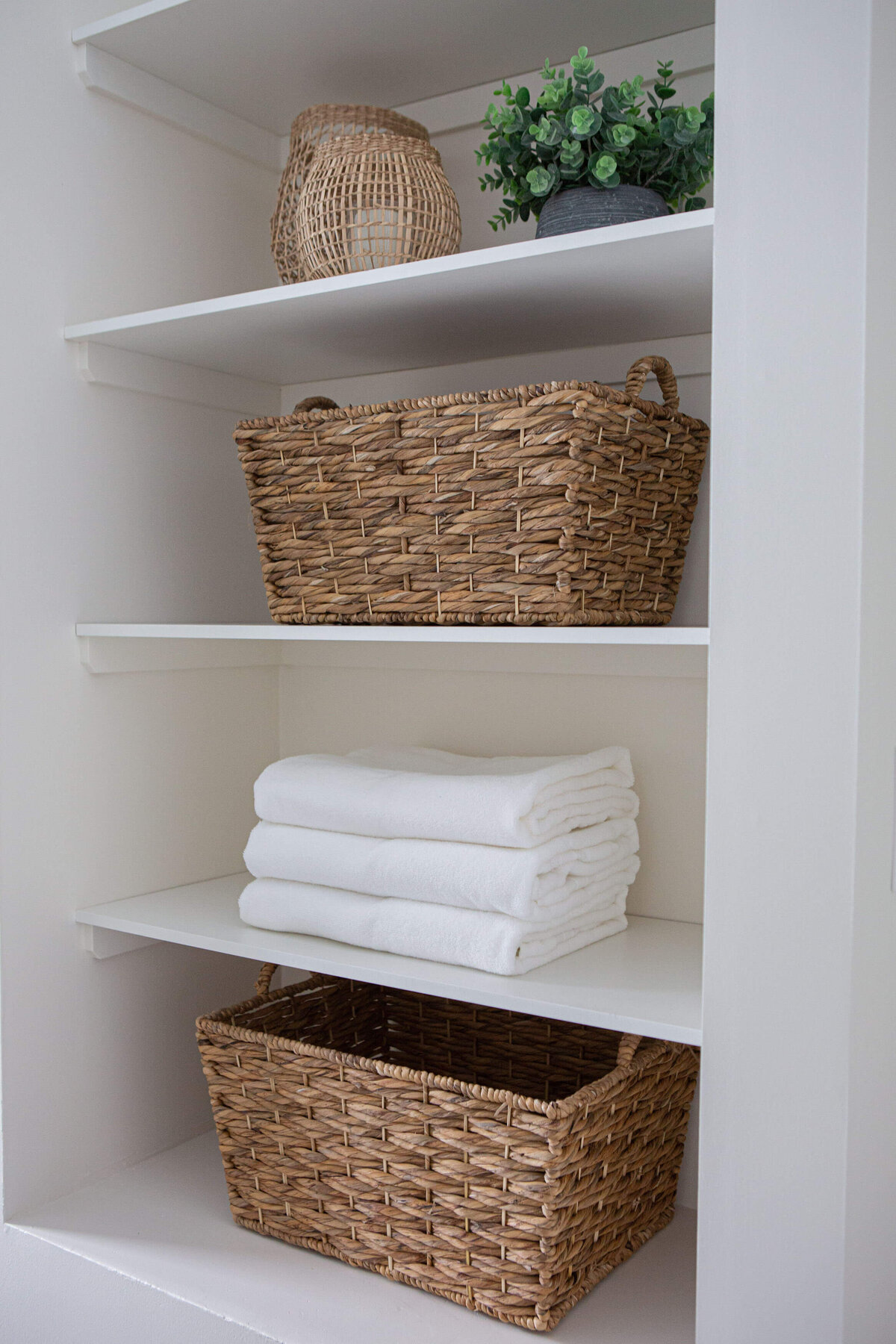 winnipeg show home laundry room shelving styled with wicker baskets and folded towels