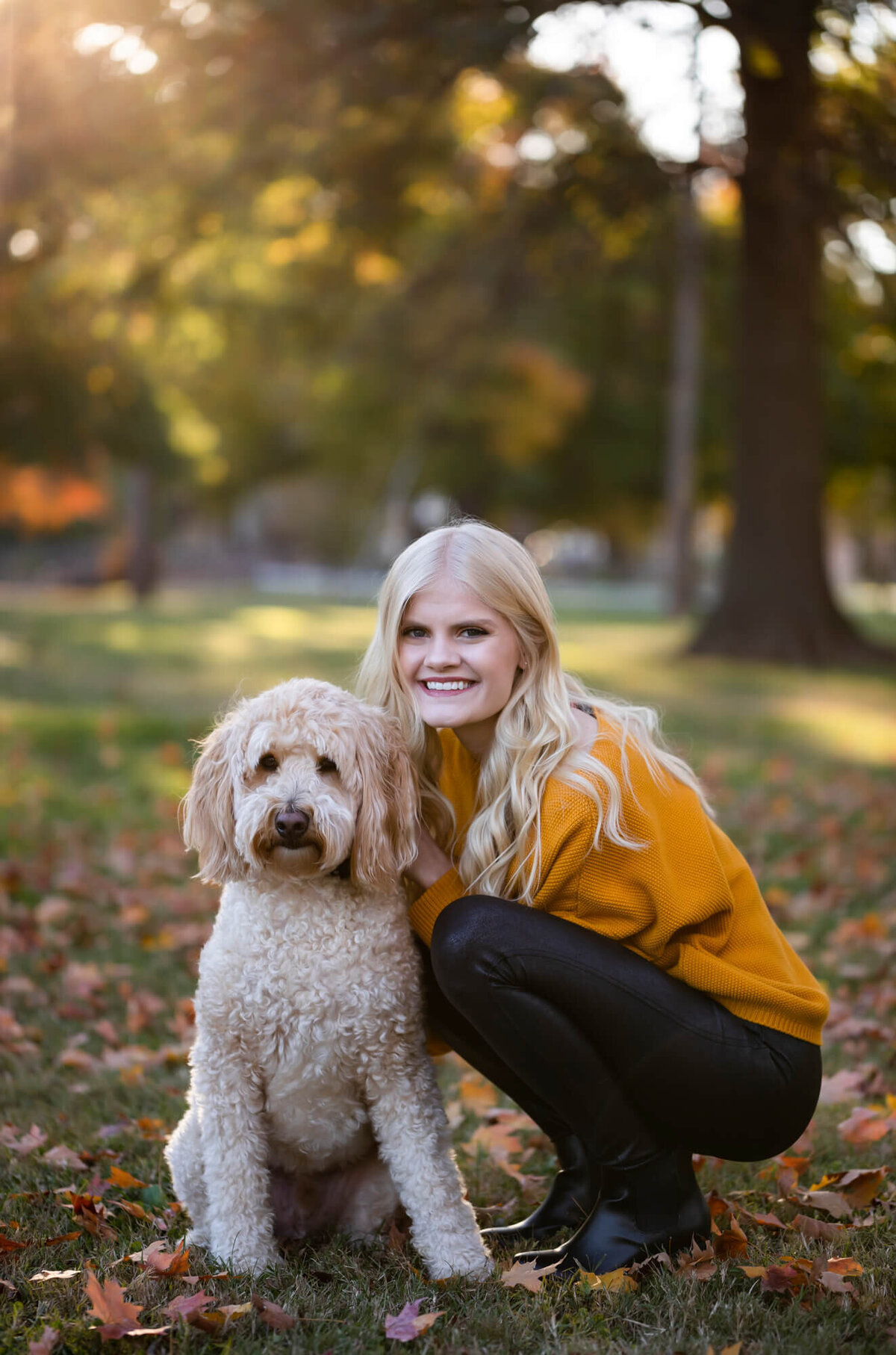 A beautiful blonde teen poses with her goldendoodle in her senior portrait. Captured by Springfield, MO senior photographer Dynae Levingston.