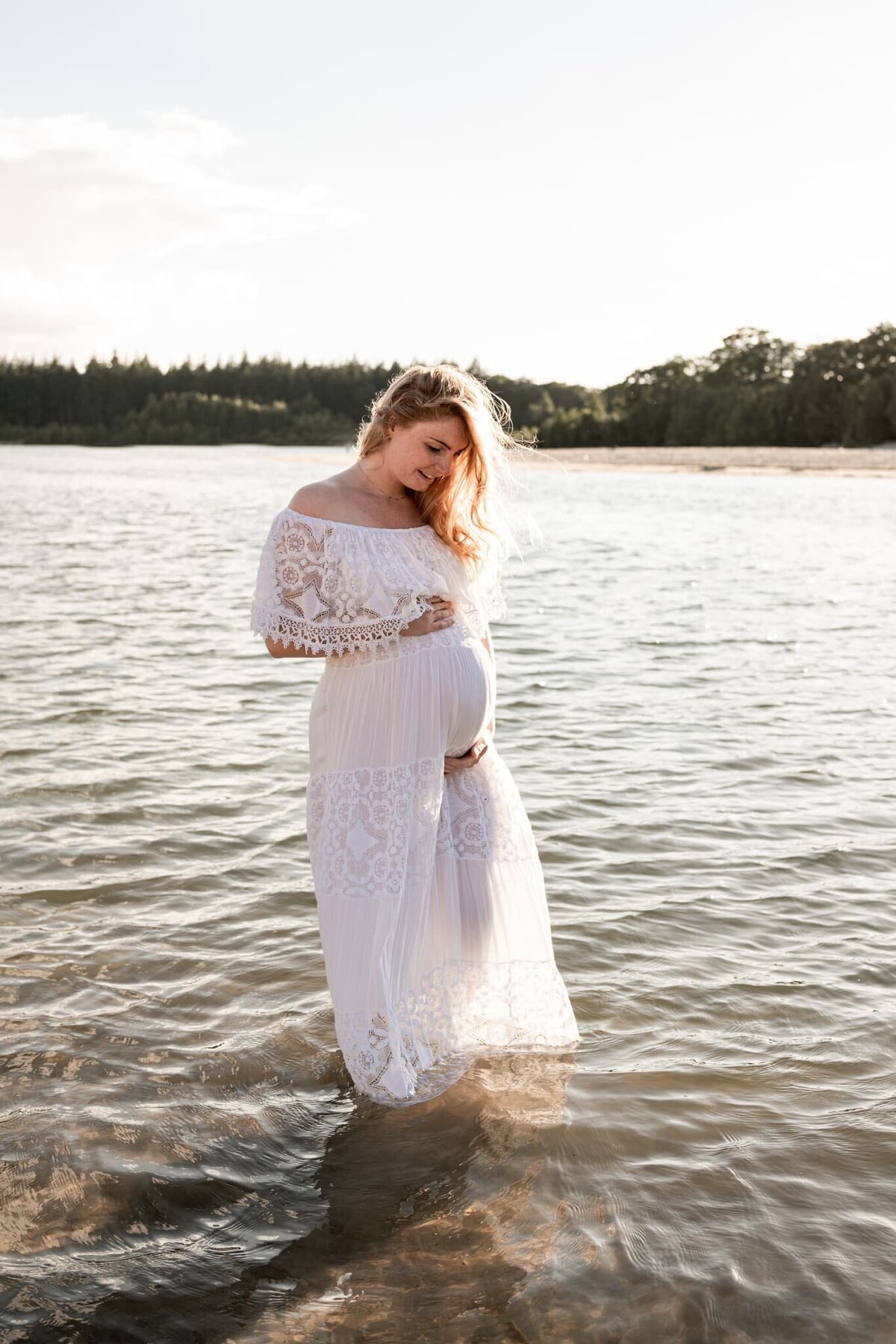 zwangerschap fotoshoot Drenthe - dromerige foto zwangere buik in het water.