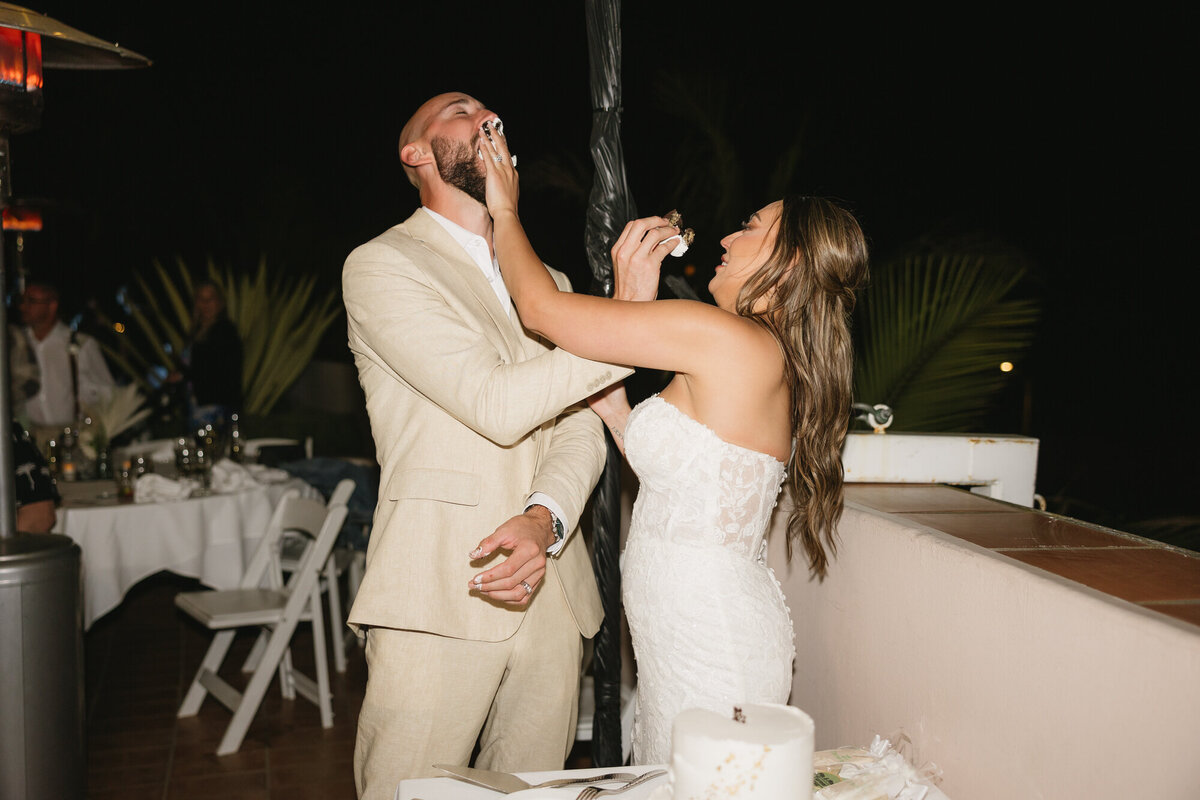 Bride and groom sharing cake during wedding reception at Hilton Beachfront Resort Santa Barbara in California