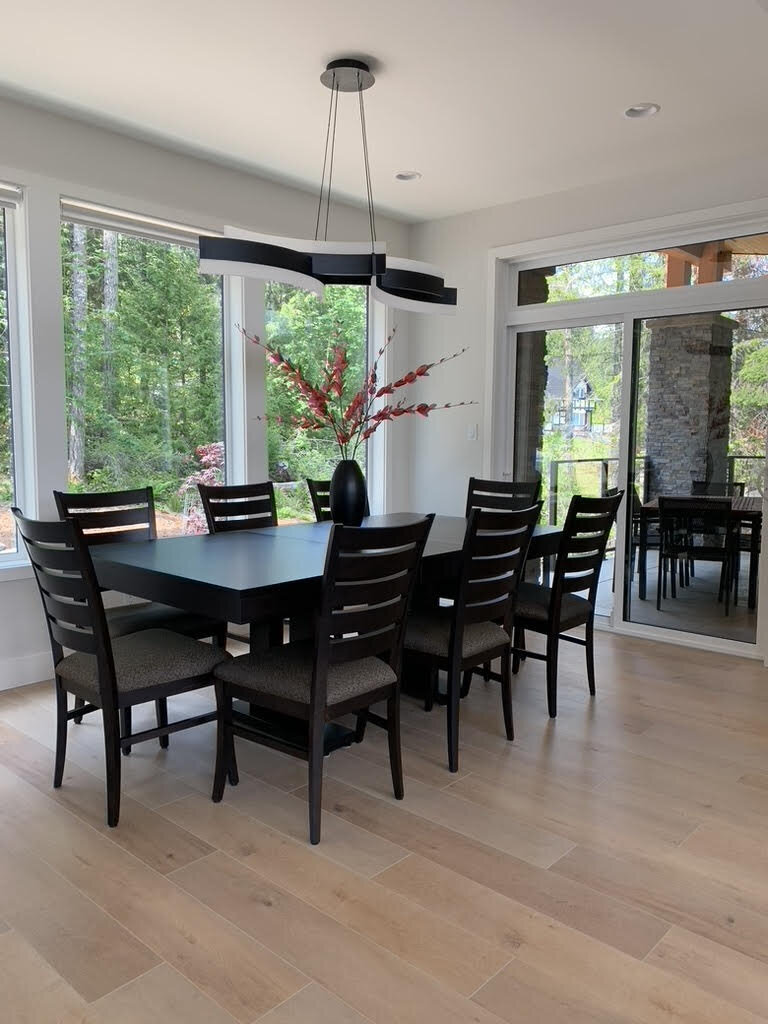 Modern dining room design with black dining table and chairs and hanging pendant light.
