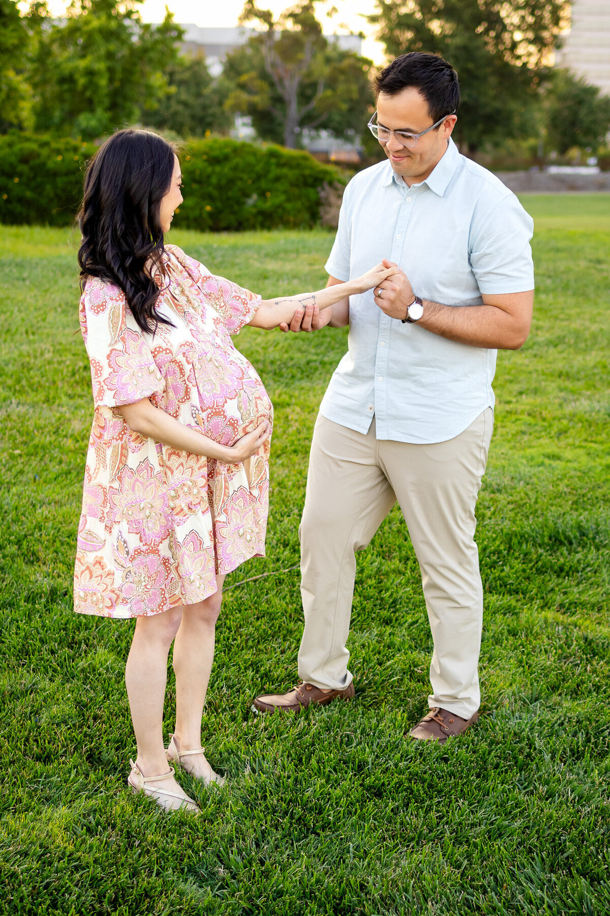 Playful couple sharing a sweet moment during a maternity session on a grassy lawn — Bay Area Maternity Portfolio - Ellobelle Photography
