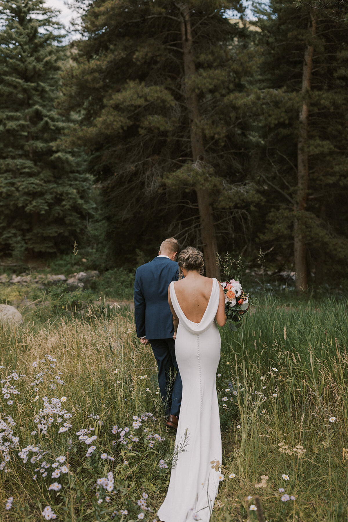 Alana and Ryan walking through the field of grass and flowers