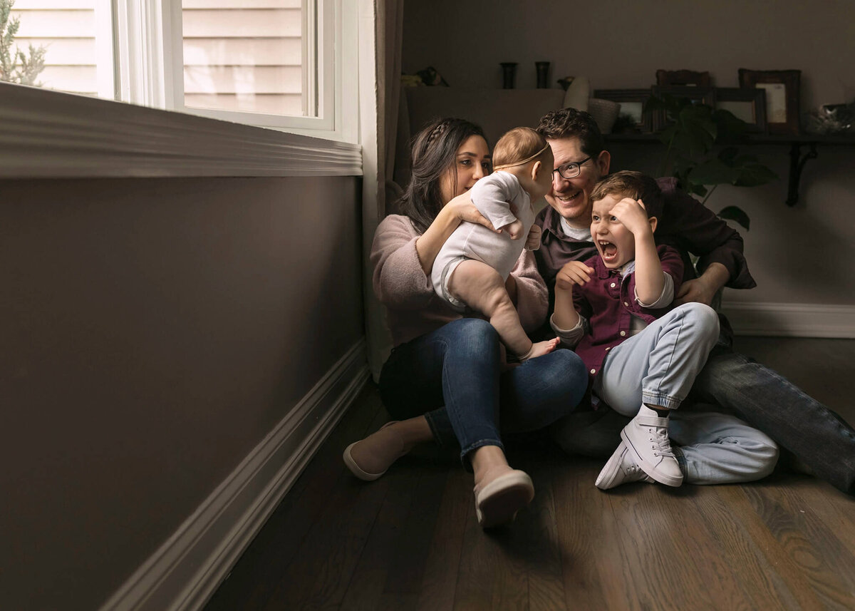 NJ portrait photographer poses family near beautiful window