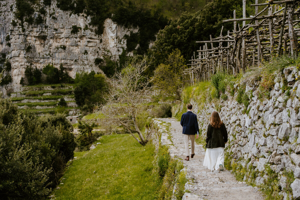 Couple walking on a mountain path.