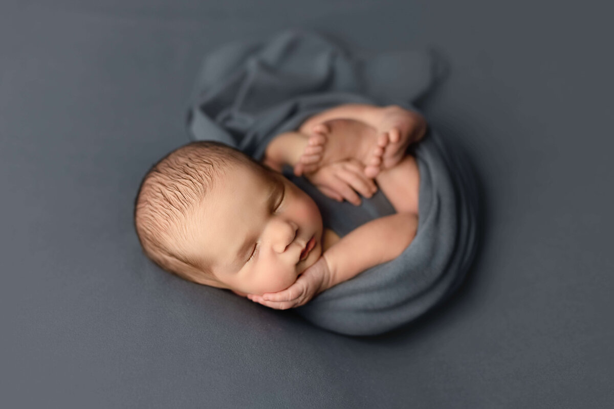 Swaddled newborn on blue blanket