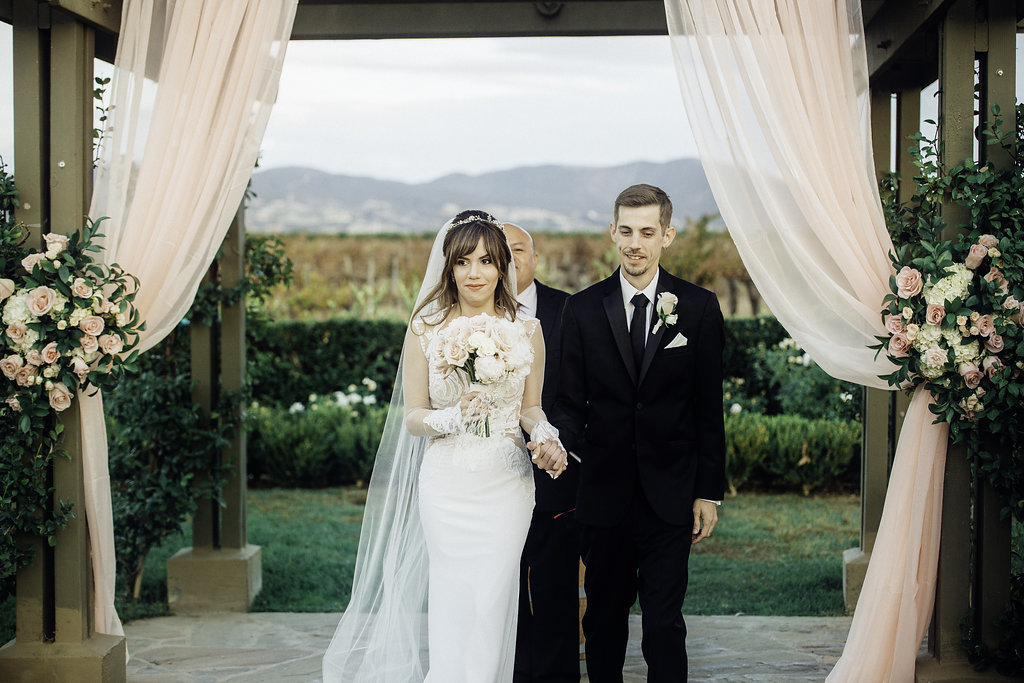 Wedding Photograph Of Bride Carrying a Bouquet Beside Her Groom Los Angeles