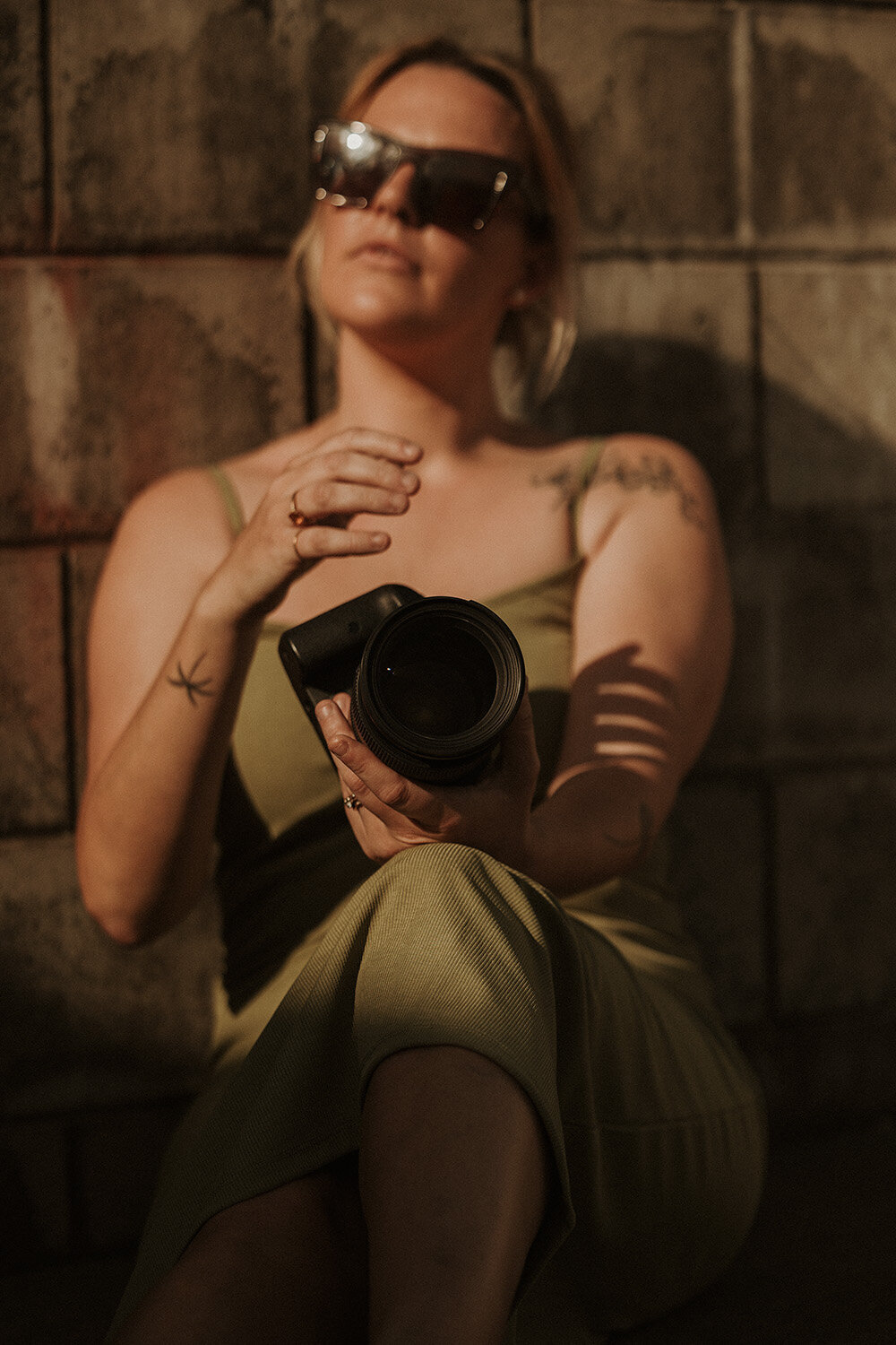 Cool and composed branding portrait of a photographer holding her camera, styled by a Sunshine Coast branding photographer.