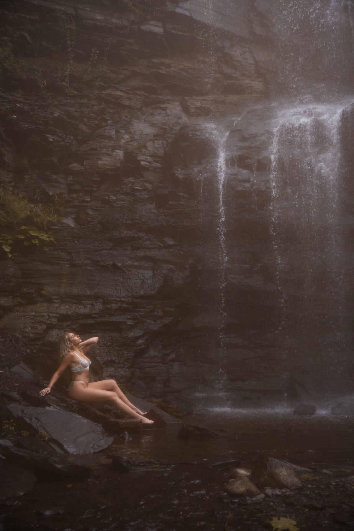 Relaxing at the base of a waterfall during an outdoor boudoir photoshoot near Albany, NY.