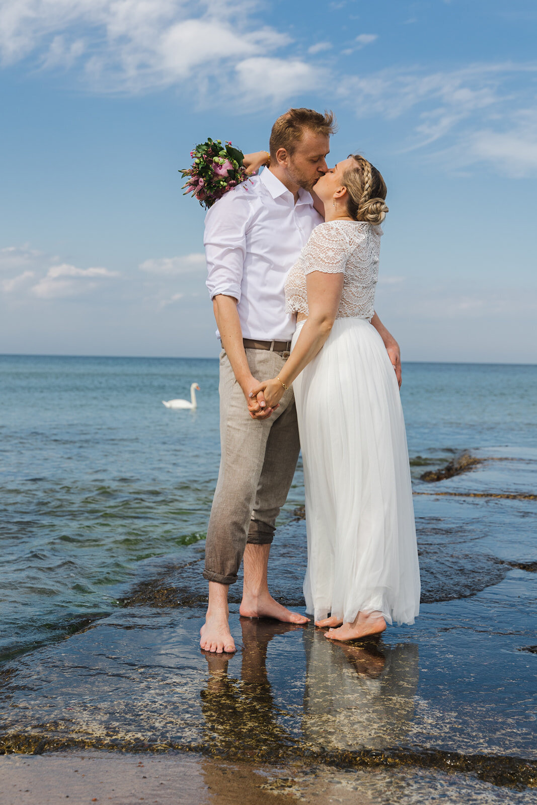 A bride and groom embracing at the beautiful Bornholm Island, a stunning wedding destination, after booking their elopement package for two