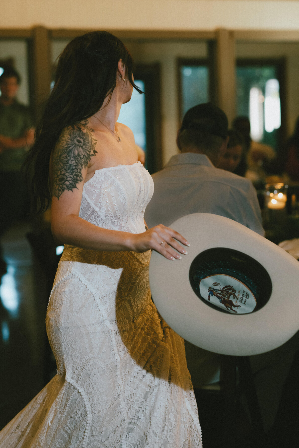 bride holding her cowboy hat at wedding reception in austin tx
