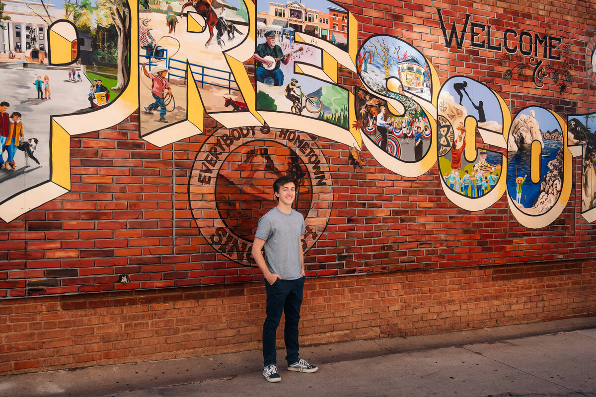 Boy poses by mural downtown for Prescott senior photographer Melissa Byrne