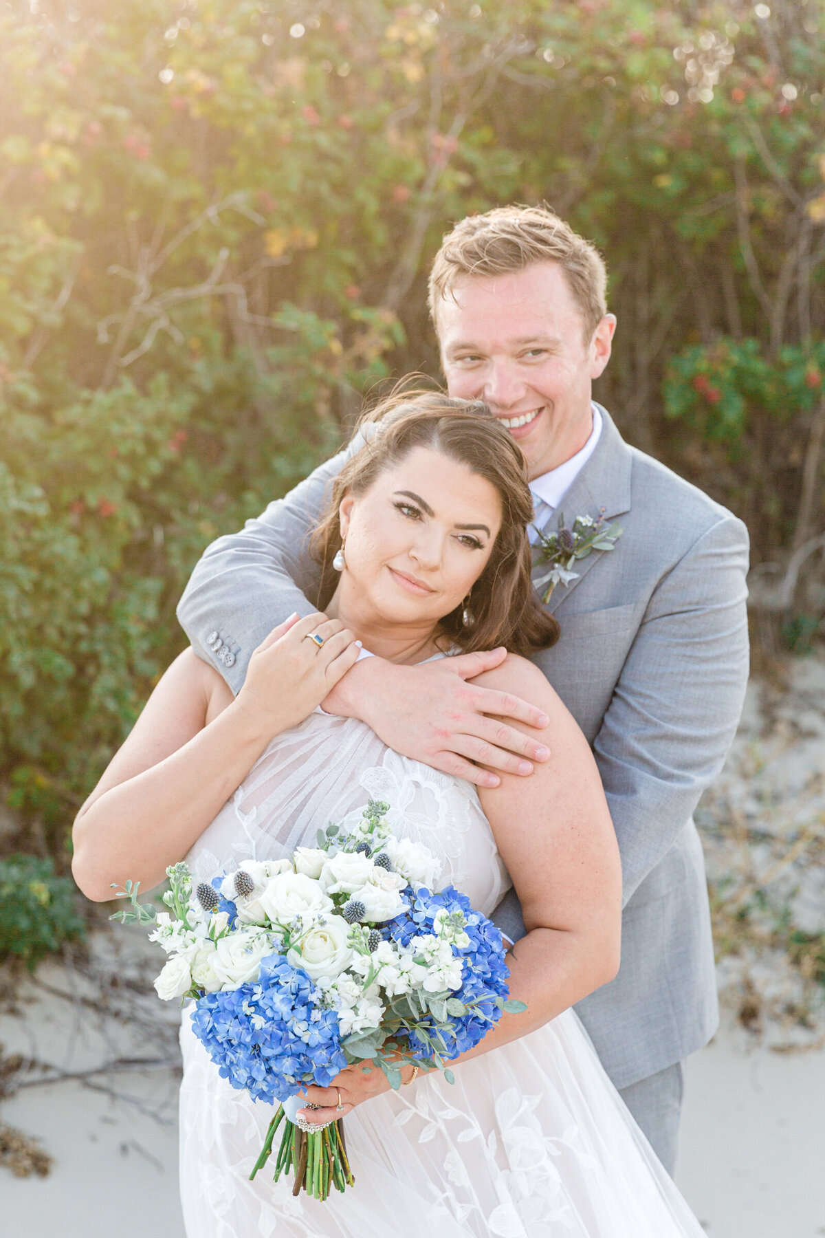 A bride and groom share a private moment  on the dunes of Cape Cod