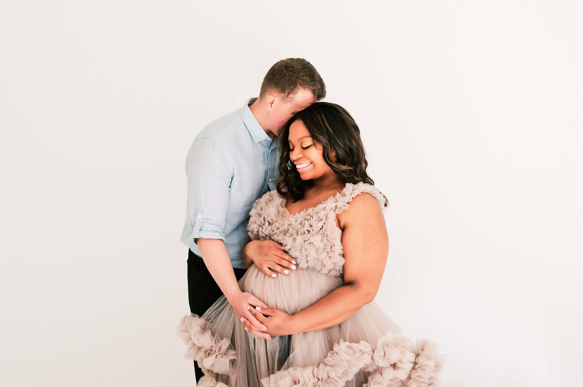 pregnant couple cuddling in studio during Springfield MO maternity photography  session