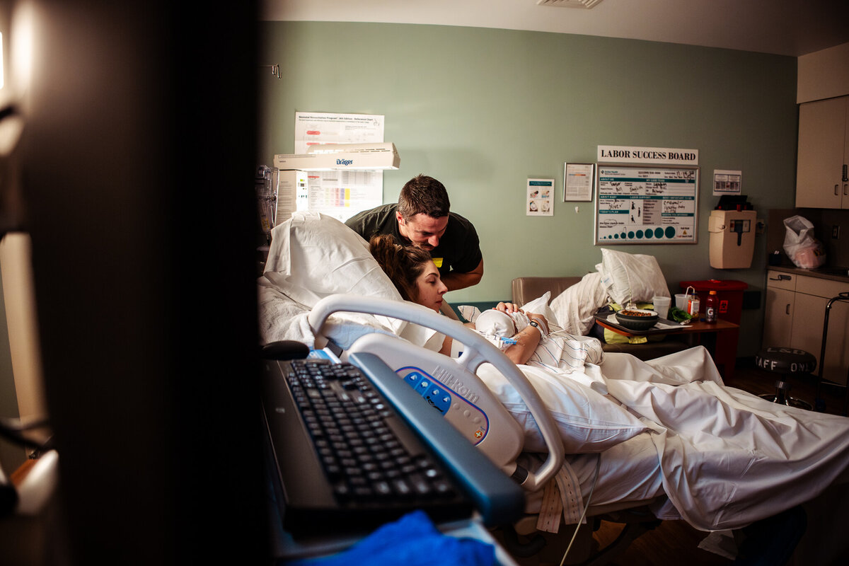A father looks in awe at his new baby right after the baby was born.  Mother was supported by Modesto Doula Shayna Cox. 