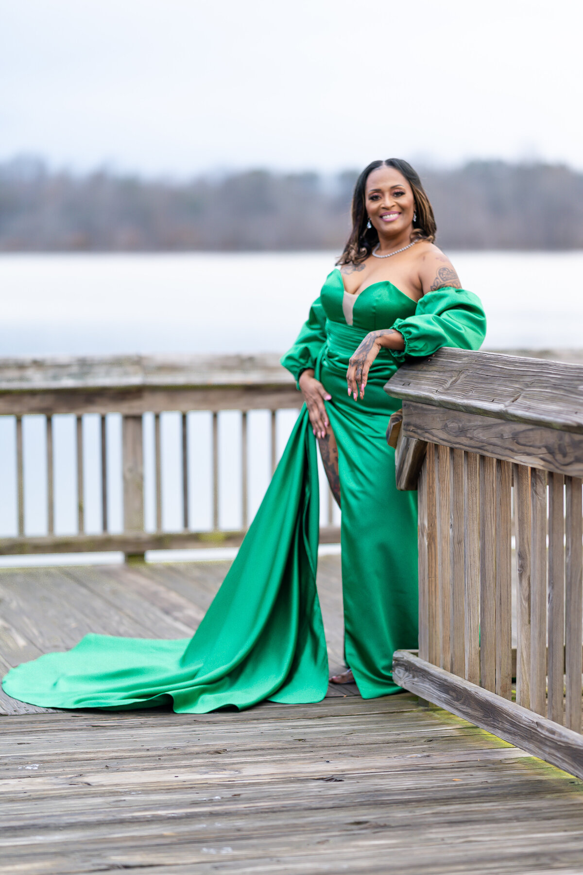 50th milestone birthday photoshoot woman wearing green ball gown by a lake