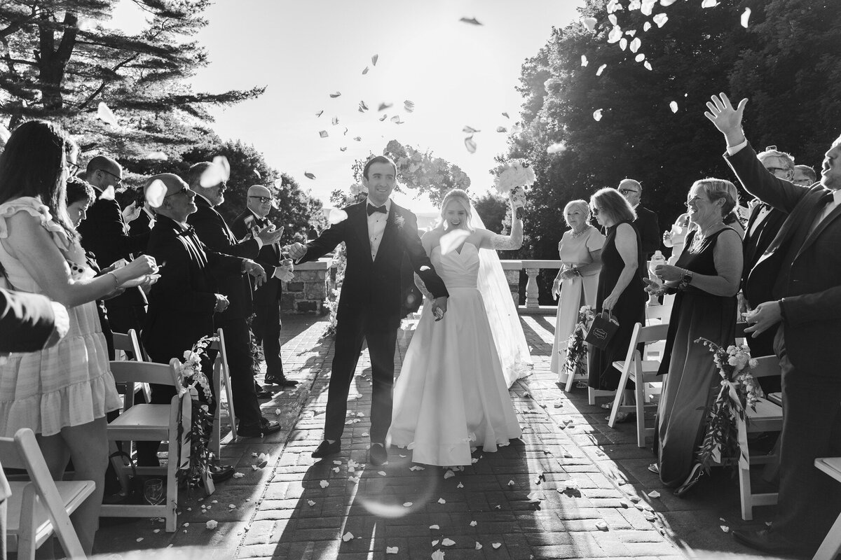 Black and white recessional with the couple walking down the aisle as guests toss confetti