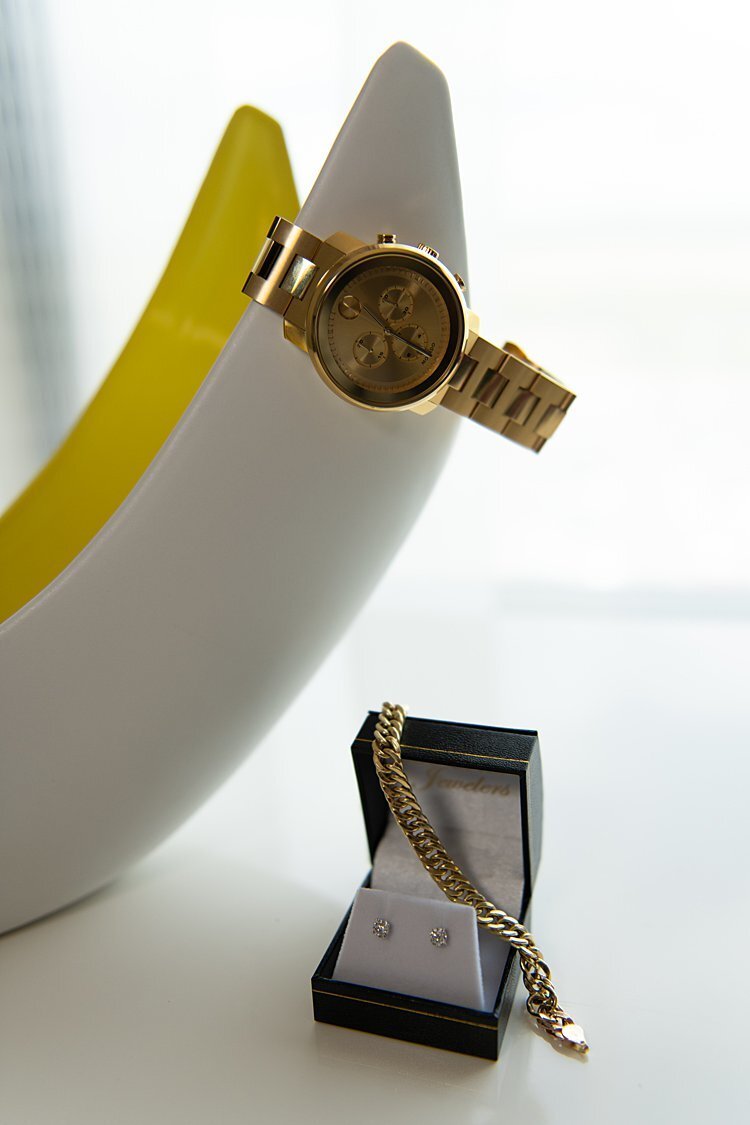Gold Movado watch, gold bracelet and diamond stud earrings with white and yellow vase
