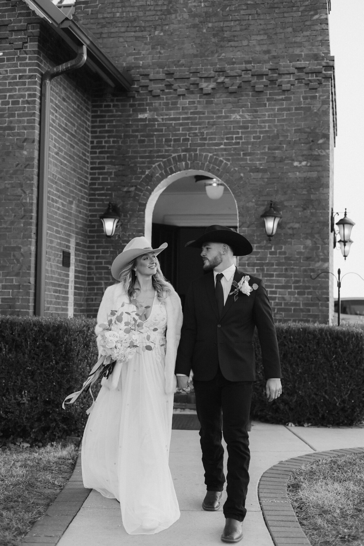 Timeless Black and White Wedding Kiss Under Historic Archway