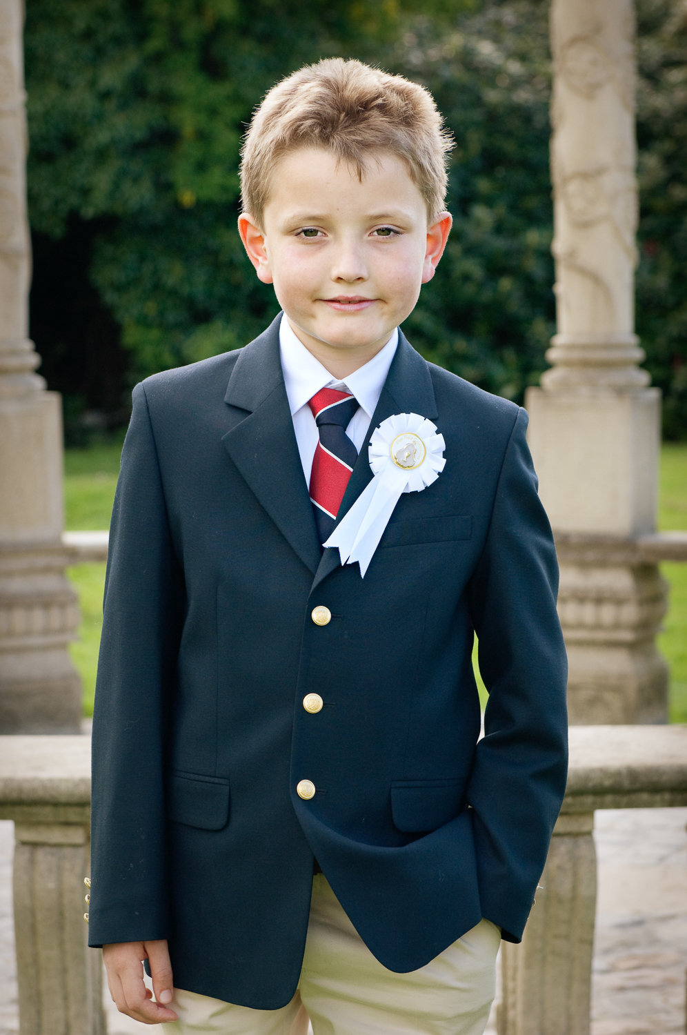 portrait of a boy in a communion suit with red stripy tie in ballyseede castle garden