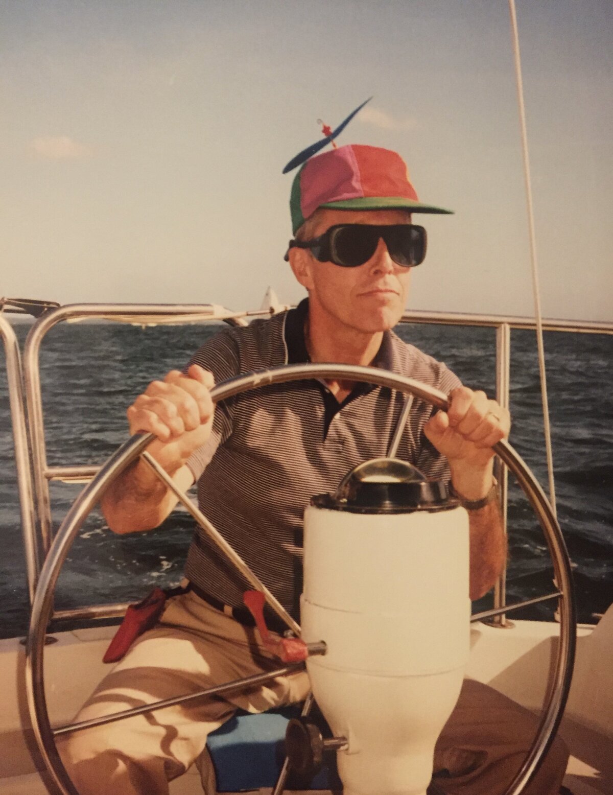 Man wearing a pinwheel hat steering a boat - Washington DC Family Photographer