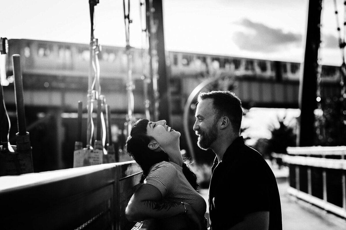 A couple laughs together on the 606 during a Wicker Park engagement session.