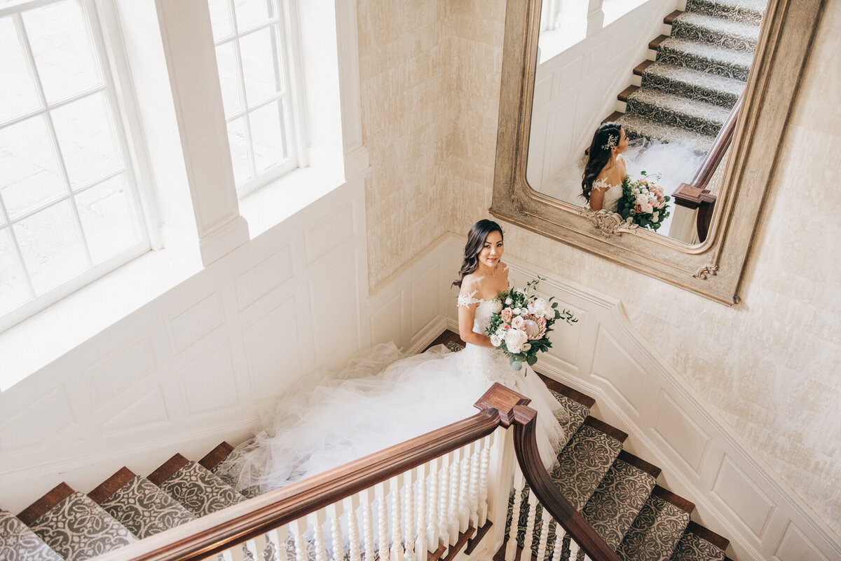 Luxurious wedding portraits of bride walking down grand staircase