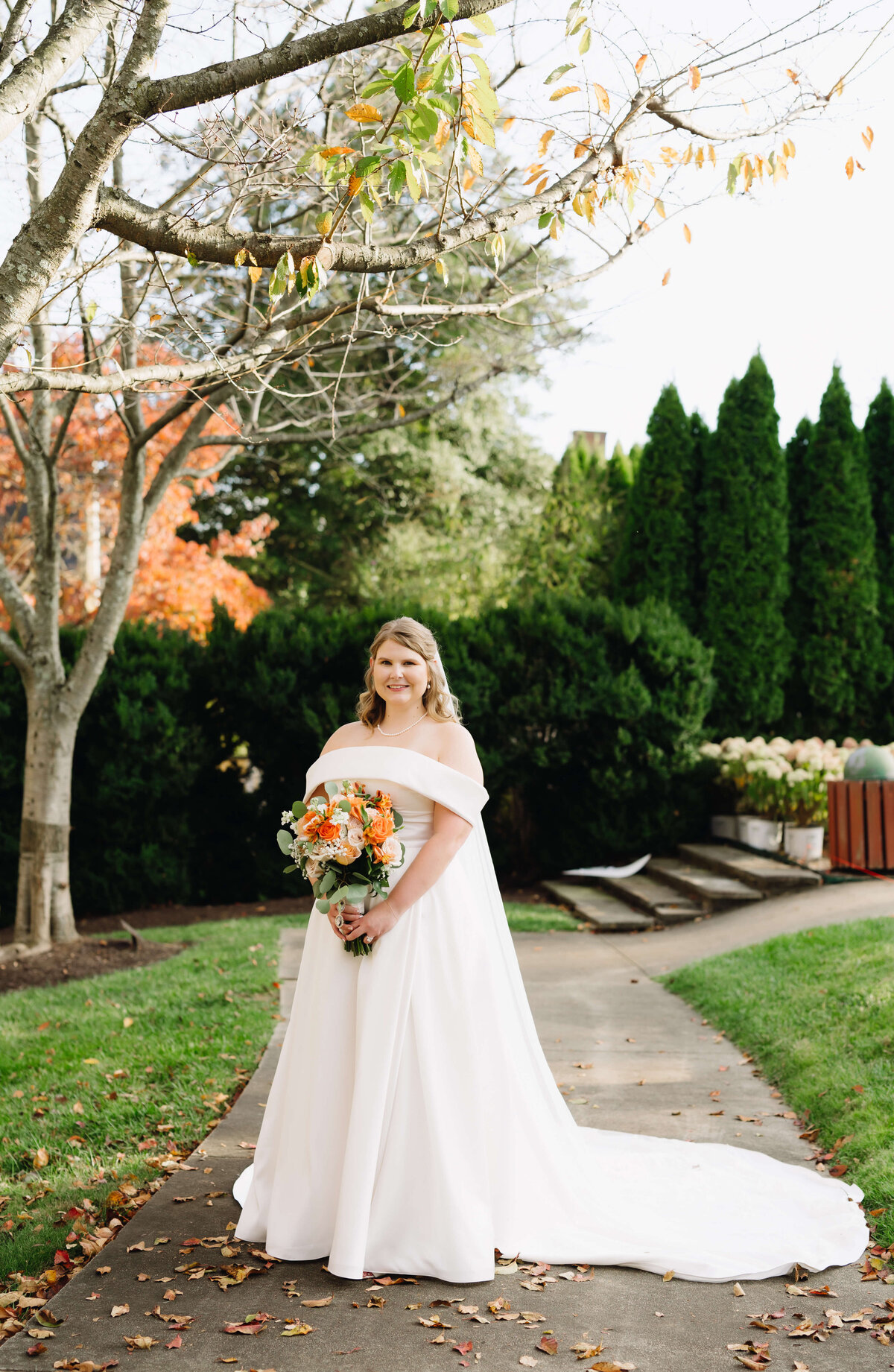 Richmond weddings with Virginia wedding photographer capturing bride in a freshly manicured lawn at a venue in the autumn months with leaves on the ground