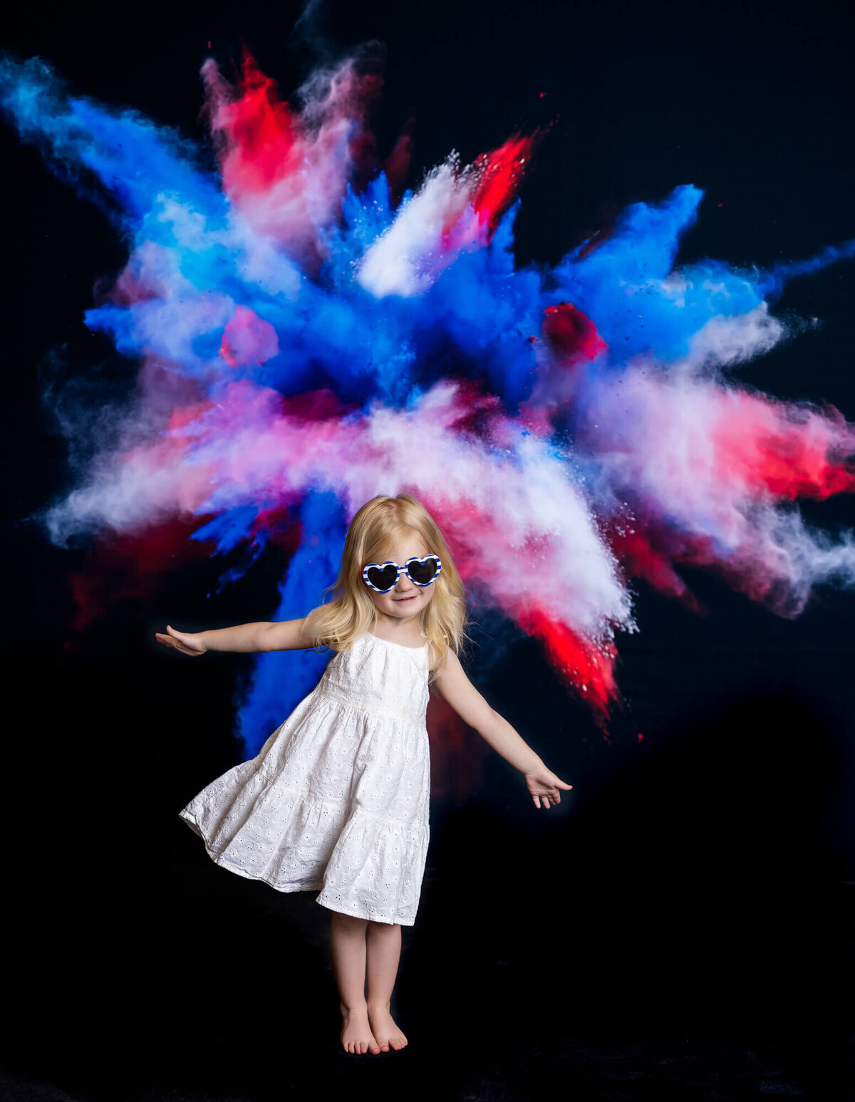 Young girl poses in front of red white and blue chalk burst in mini session  Prescott kids photography session