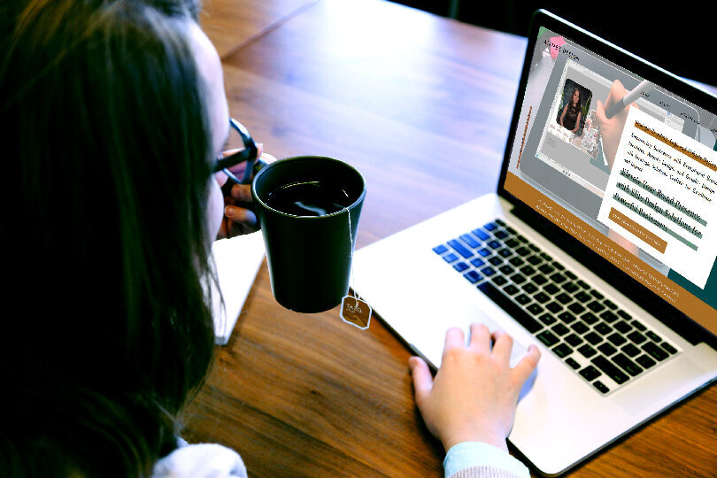 This photo shows a woman sitting and drinking tea while looking at her laptop with the website of ATamez Design a Brand Identity and website design expert company.
