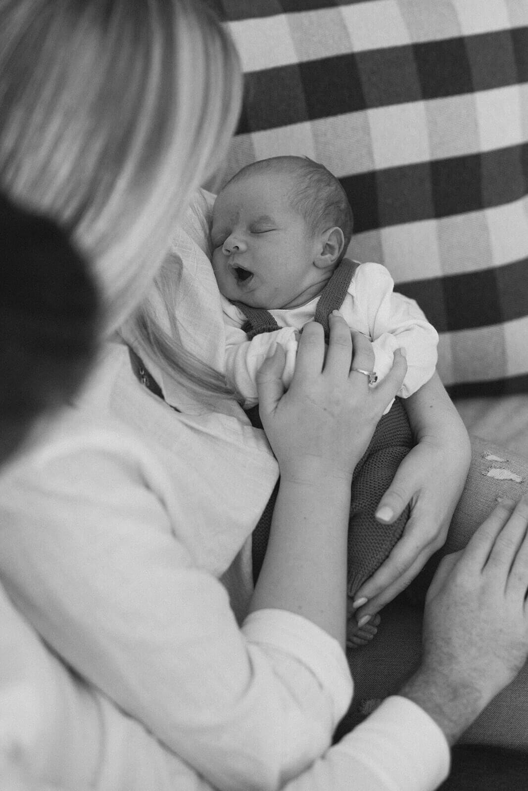 woman  looking down at newborn baby at newborn photoshoot at Finger Lakes, NY