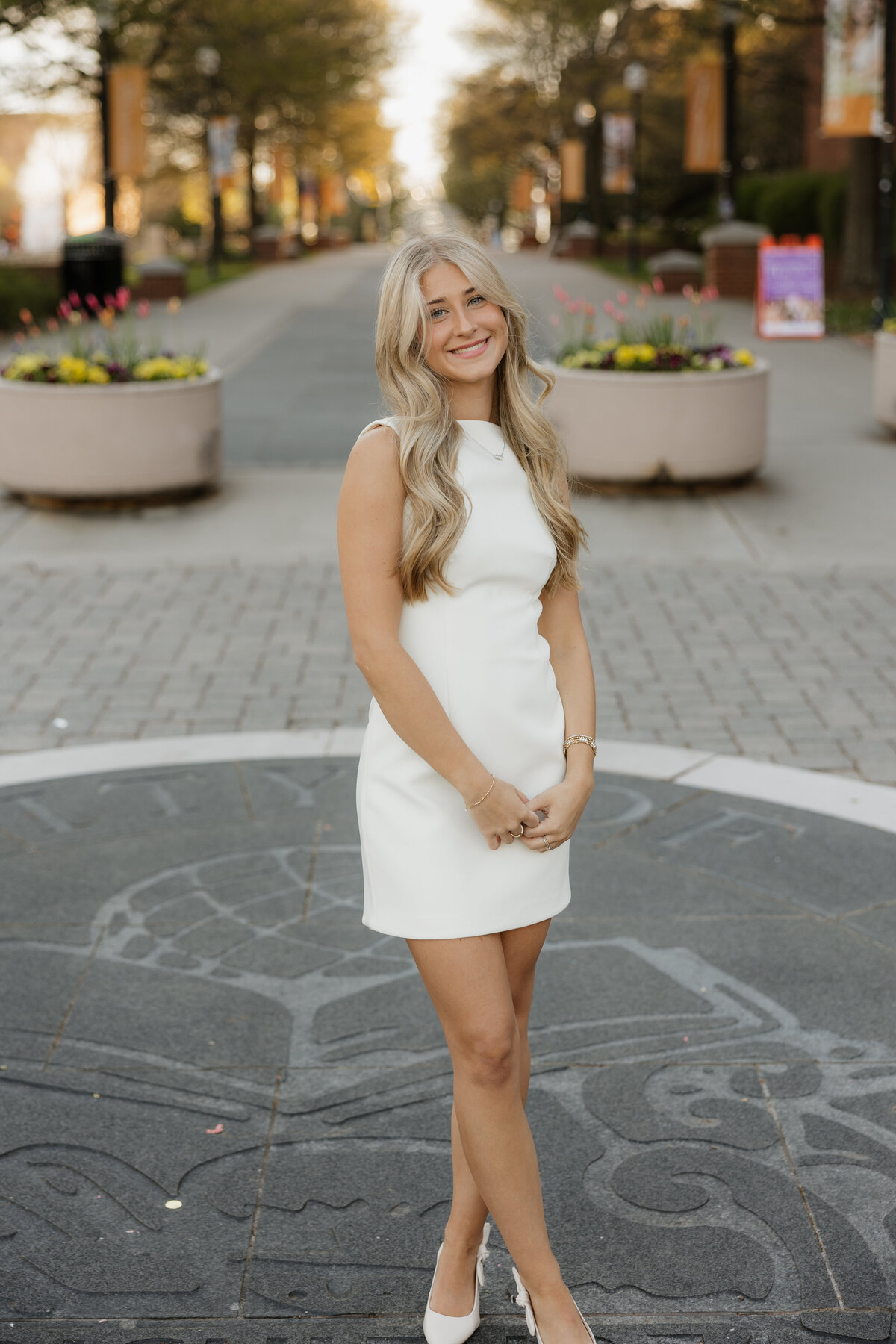 Emily holds both of her hands together  while she stands on The Seal at The University of Tennessee during her early Spring Senior pictures.